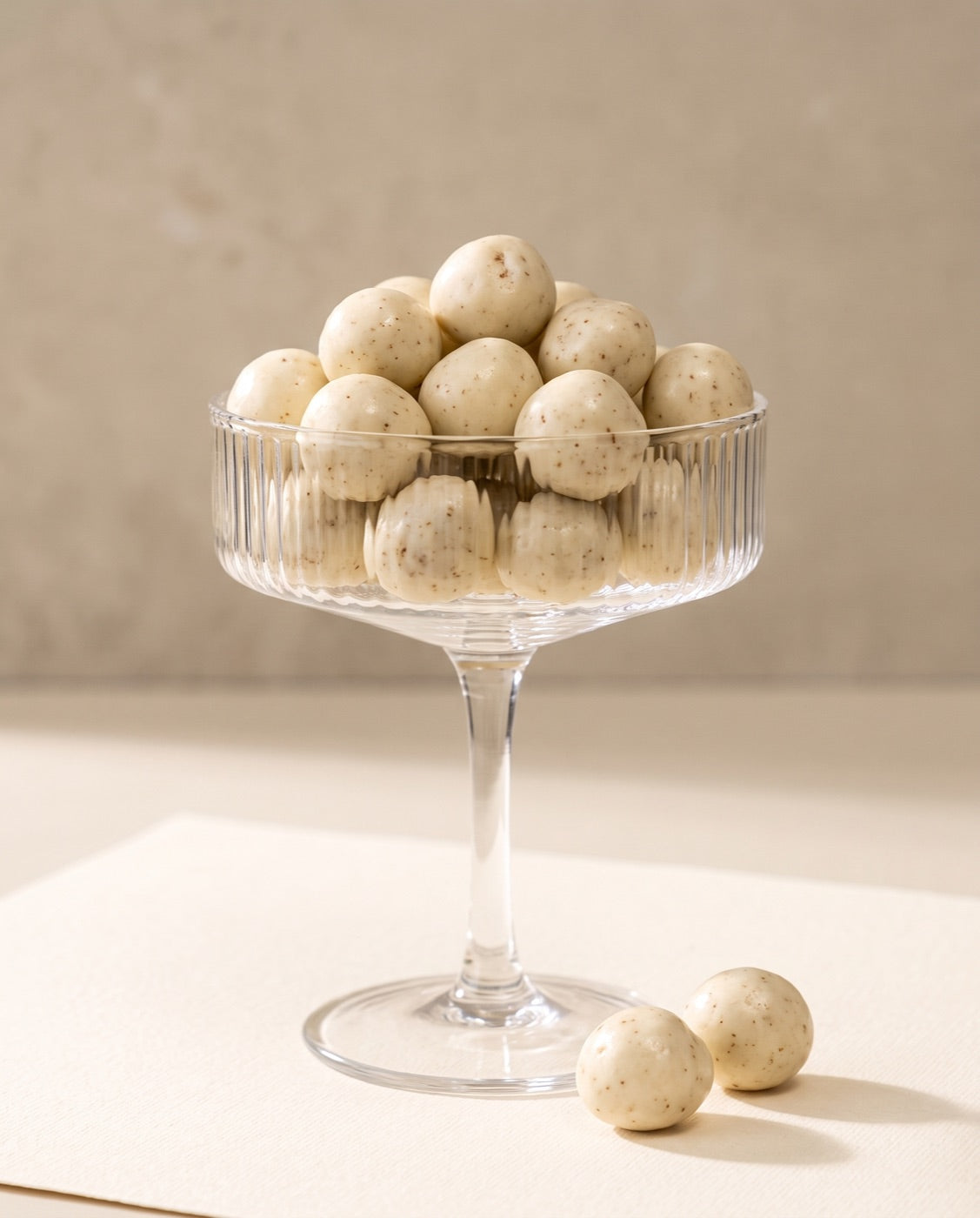 Yoghurt coated cherries piled in a ribbed coupe glass.